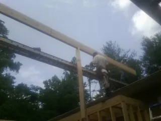 Carpenter setting a ridge beam over a new addition frame — Ice Dam Removal by Roofing Brothers in Tybee Island