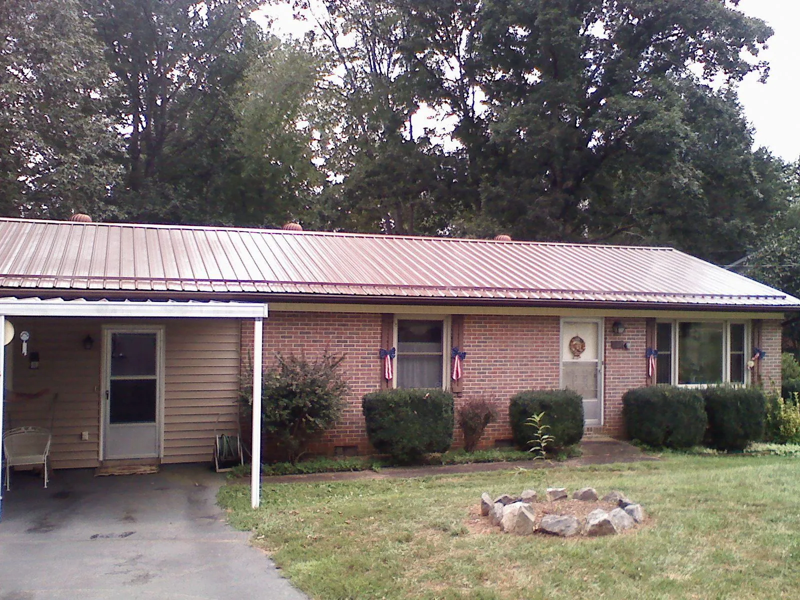 Bronze metal roof and carport on a brick ranch home — Roof Repair work by our crew in Tybee Island